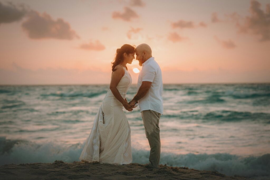 pexels-photo-32504943-32504943 A couple embraces at sunset during a beach wedding in Costa Mujeres, Mexico.